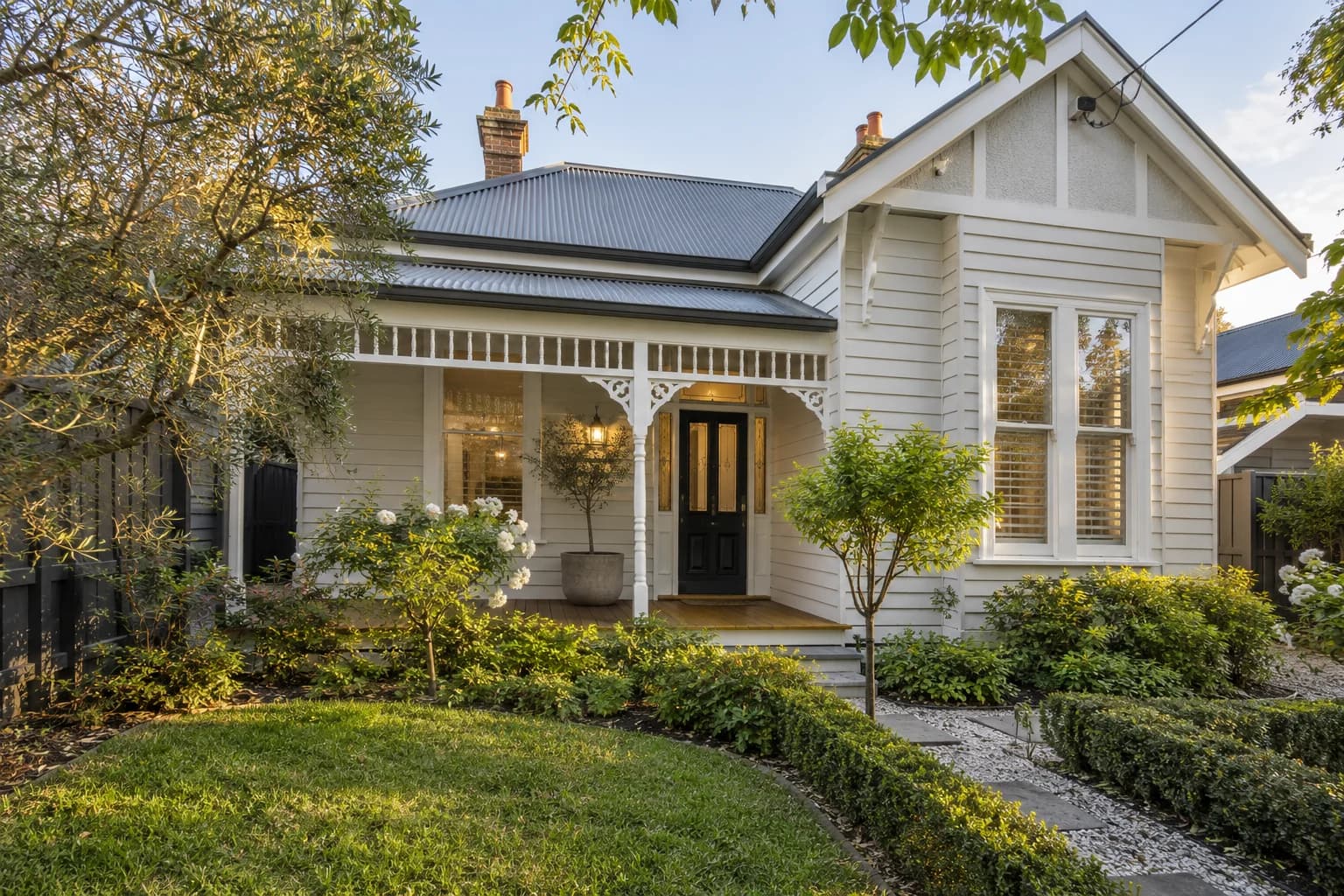 A weatherboard home with a veranda and established garden