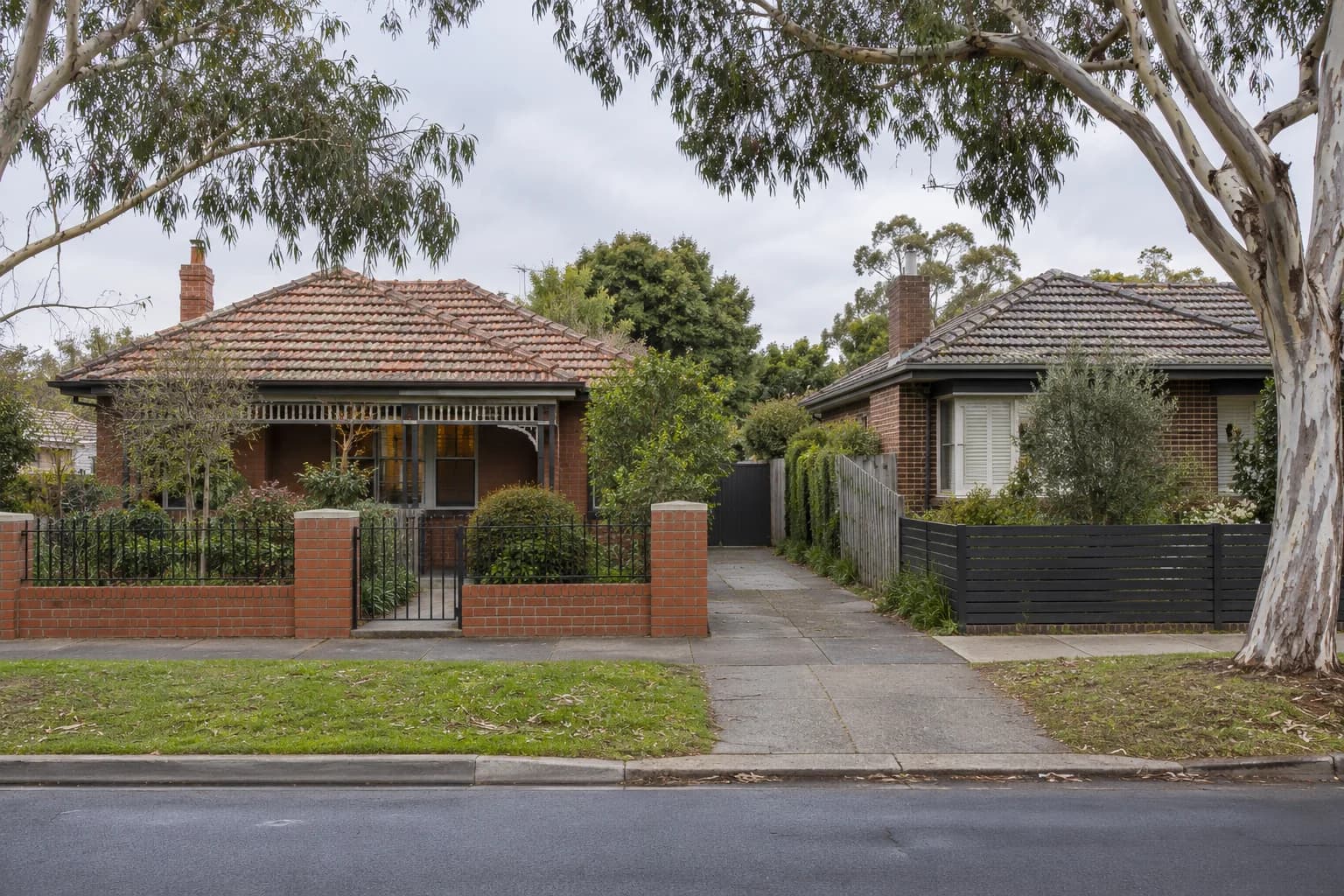 A quiet suburban street with brick homes and established trees