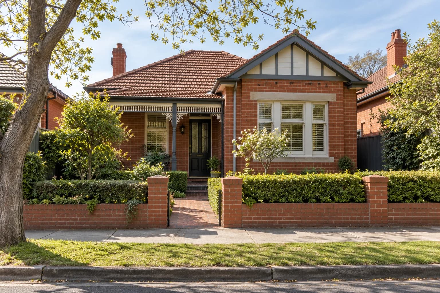 A red brick suburban home behind a low garden wall