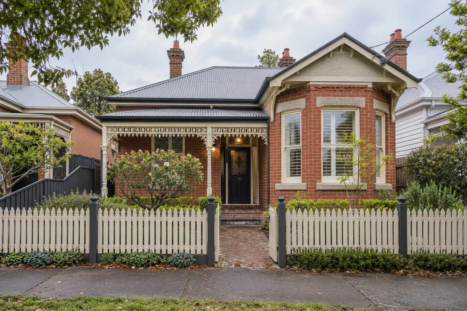 A red brick Melbourne-style home with a small front garden